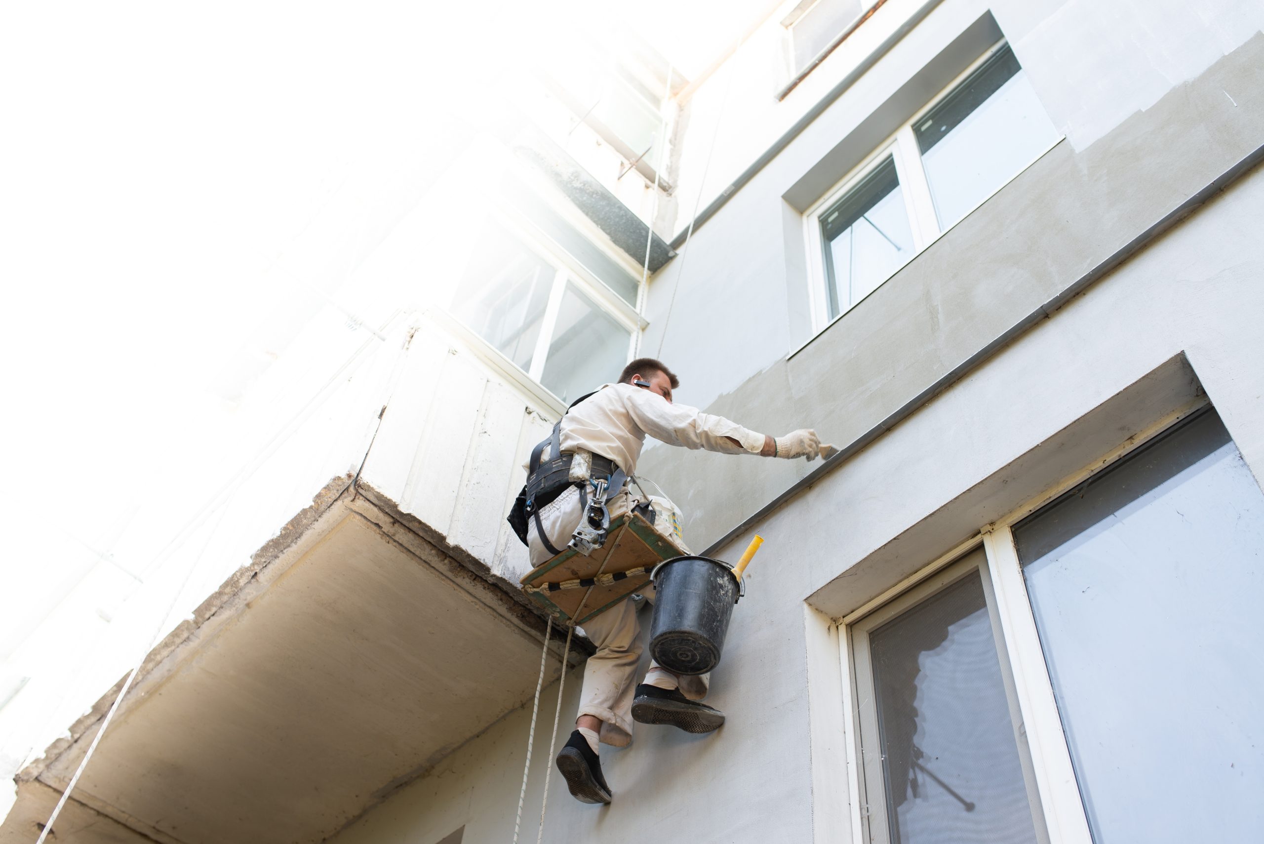 constructor relizando reformas en fachada trabajo en altura sin andamio scaled